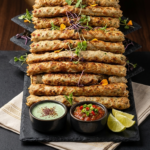 Food Forest Catering artisanal chicken seekh kabab platter on slate board with mint chutney tomato salsa and lemon