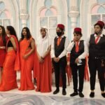 Food Forest Catering service team in orange sarees and black uniforms standing at decorated wedding venue